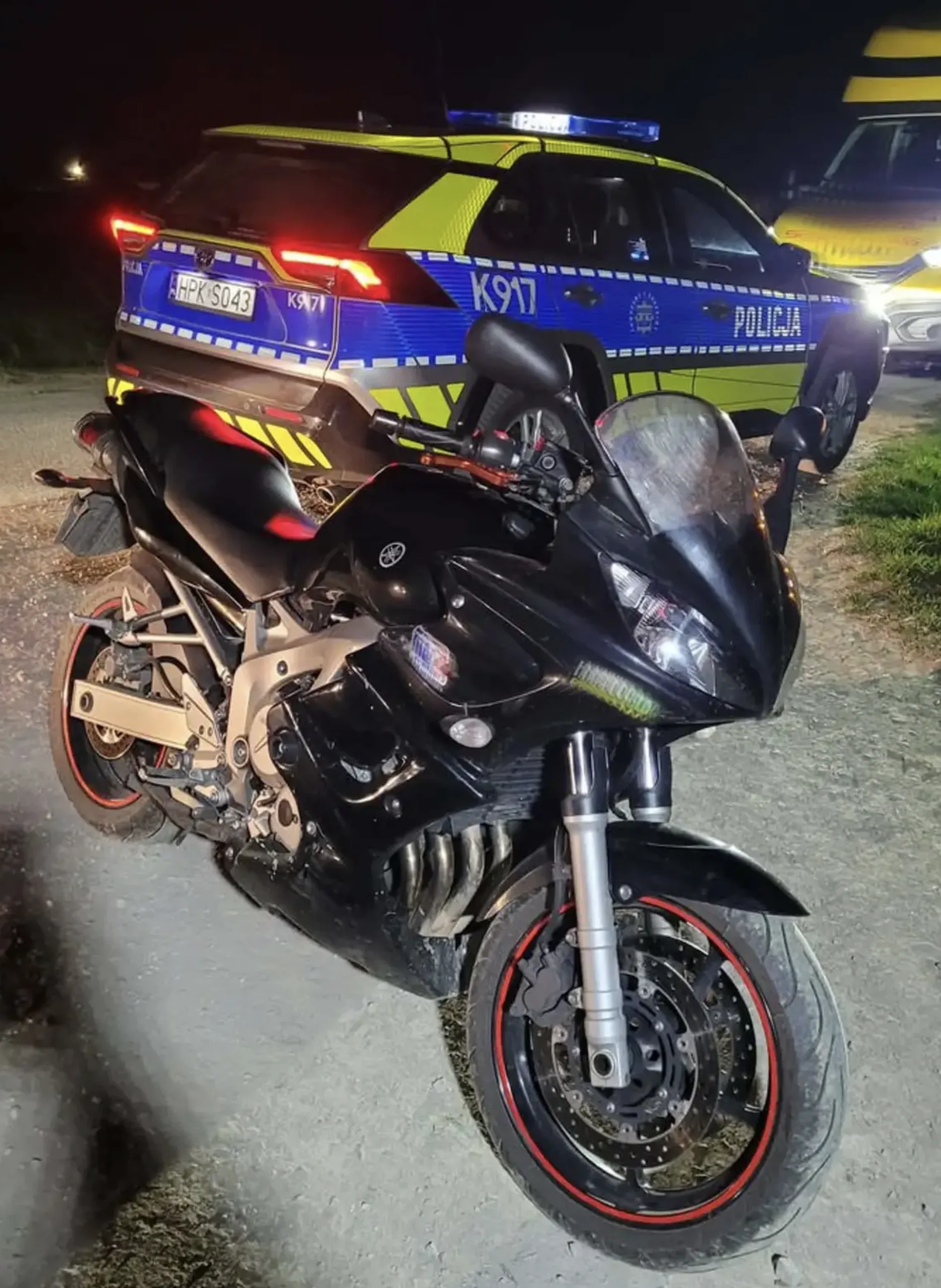 Uszkodzony motocykl leżący na poboczu drogi po nieudanej próbie ucieczka przed policją konsekwencje której poniósł nietrzeźwy kierowca.