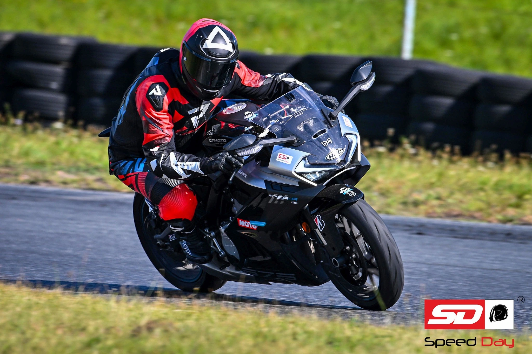 Protest motocyklistów przeciwko zamykaniu torów wyścigowych w Polsce, widoczny pusty tor Poznań z flagami sportowymi.