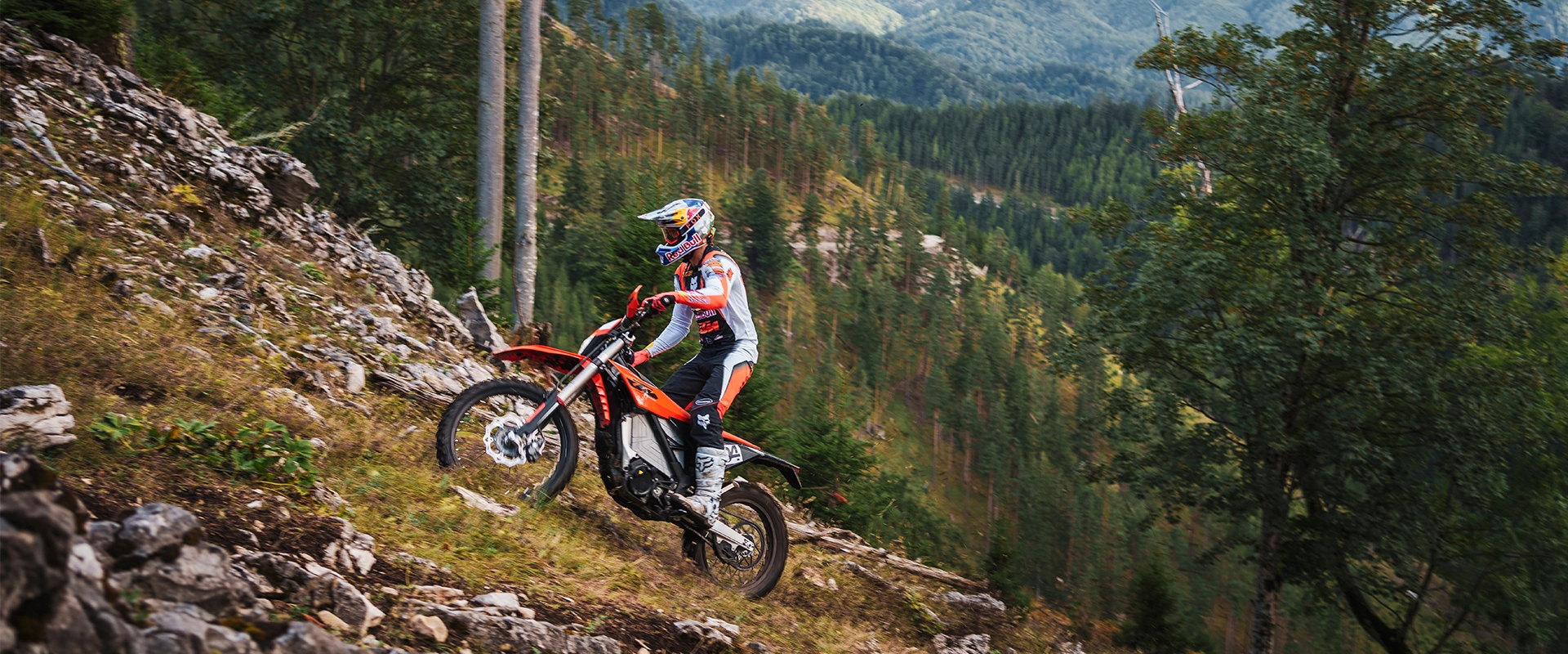 Nowy elektryczny motocykl KTM Freeride E 2027 w akcji na leśnej ścieżce, prezentujący lekką konstrukcję i terenowe opony.