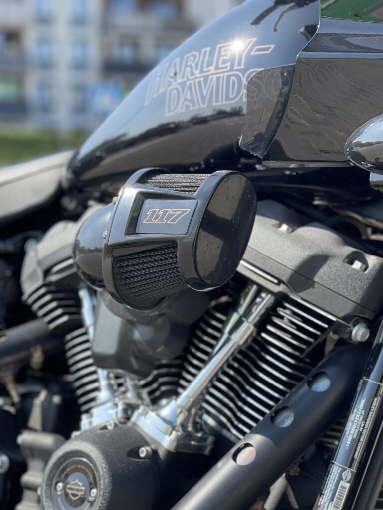 Nowe modele motocykli objęte akcja serwisowa Harley-Davidson 2026 zaparkowane przed salonem, w tle widoczne logo marki i akcesoria dżinsowe.