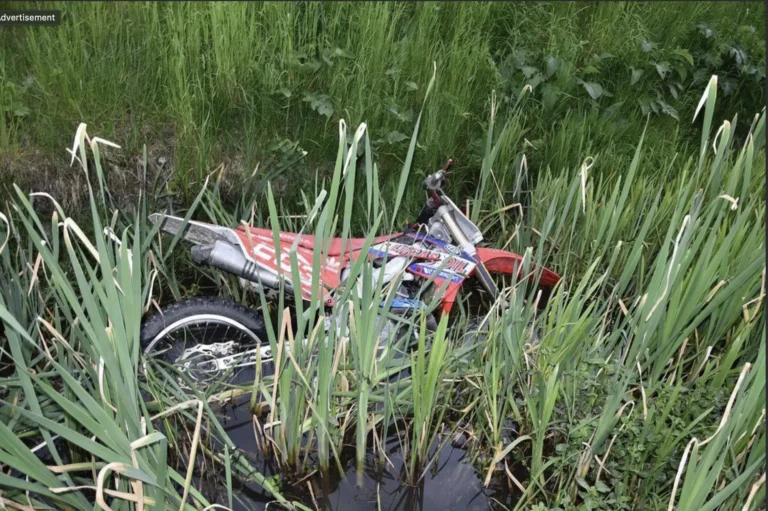 Groźny wypadek na crossie Chełm i okolice zbiornika w miejscowości Staw, strażacy wyciągający zalany motocykl terenowy z głębokiego rowu z wodą.